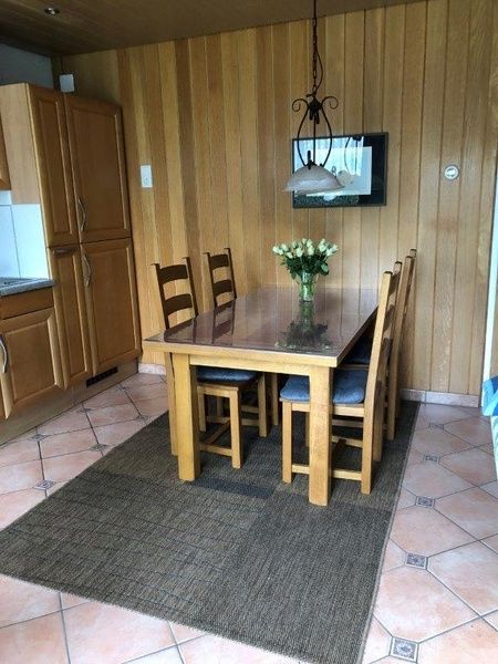 Esszimmer im Ferienhaus Slufterhoek 128, De Cocksdorp Texel, mit Holztisch und Stuehlen.