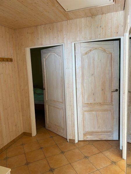 Diele im Ferienhaus Slufterhoek 128, De Cocksdorp Texel, mit Holztueren und gefliestem Boden.