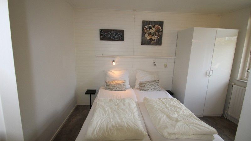 Modernes Schlafzimmer im Bungalow Tamarisk 164 - Bartje, De Cocksdorp, Texel mit reichlich Stauraum.