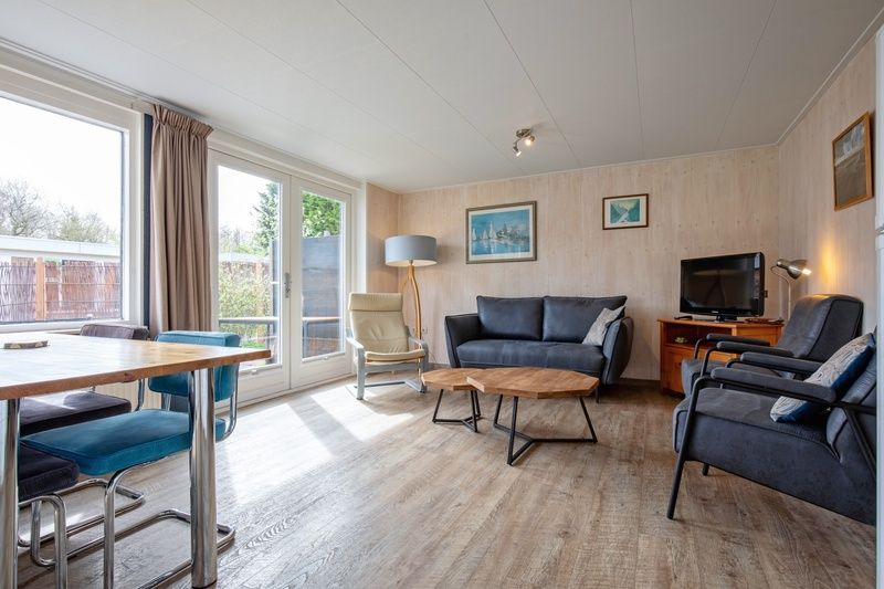 Helles Wohnzimmer von Bungalow Tamarisk 206, De Cocksdorp, Texel mit Blick auf den Garten.