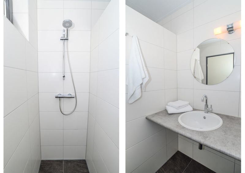 Stijlvolle badkamer in Vakantiehuis 34A, De Cocksdorp Texel, met douche en wastafel.