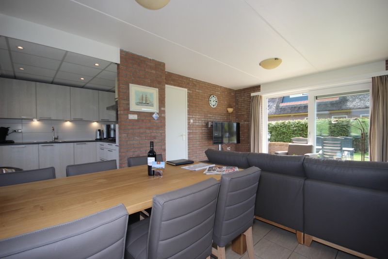 Ruime eetkamer in Bungalow De Witte Hoek 6 Pers., De Cocksdorp, Texel met moderne keuken en grote eettafel.