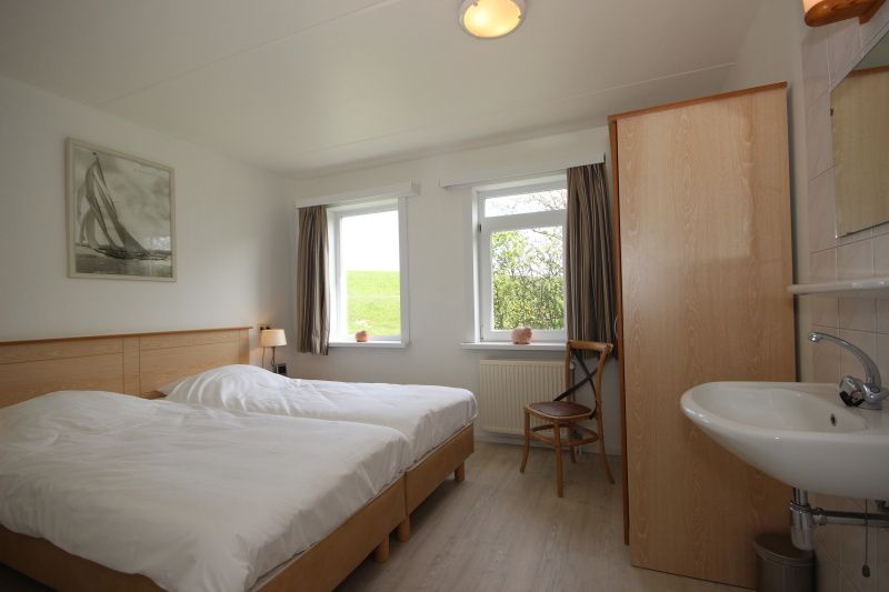 Slaapkamer met twee bedden in Bungalow De Witte Hoek 6 Pers., De Cocksdorp, Texel, lichte ruimte met uitzicht.