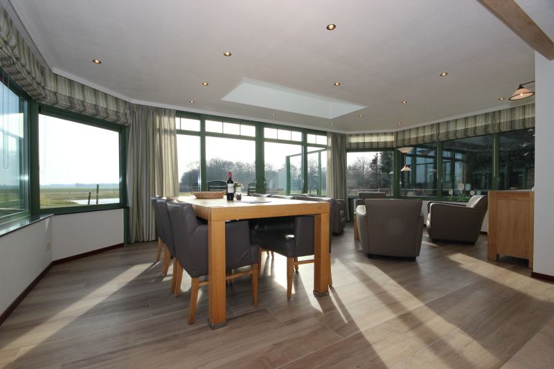 Geraeumiges Esszimmer im Wintergarten der Villa De Witte Hoek, Ferienhaus auf Texel mit Panoramablick.