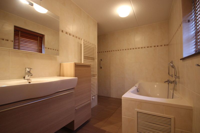 Modernes Badezimmer mit Badewanne im Wintergarten der Villa De Witte Hoek, Ferienhaus auf Texel.