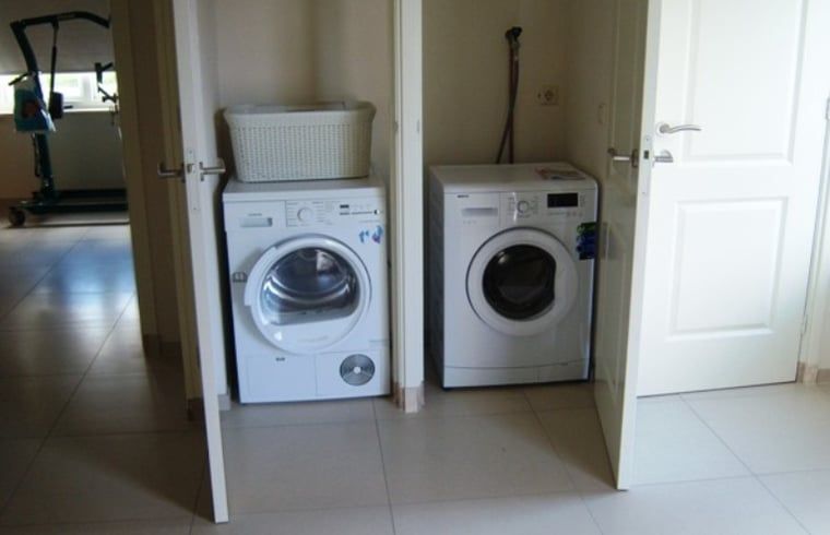 Praktische wasruimte in Huisje in De Cocksdorp, Texel, met wasmachine en droger.