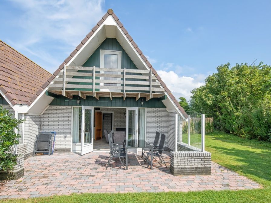 Vacation home Schelpenoord 121 in De Cocksdorp Texel offers a sunny terrace with comfortable seating.