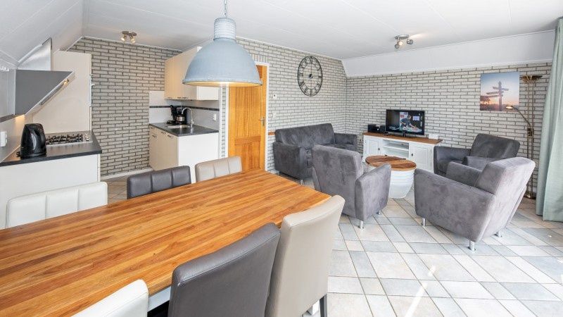 Cozy living room with dining area in Holiday home Schelpenoord 121, located in De Cocksdorp on Texel.