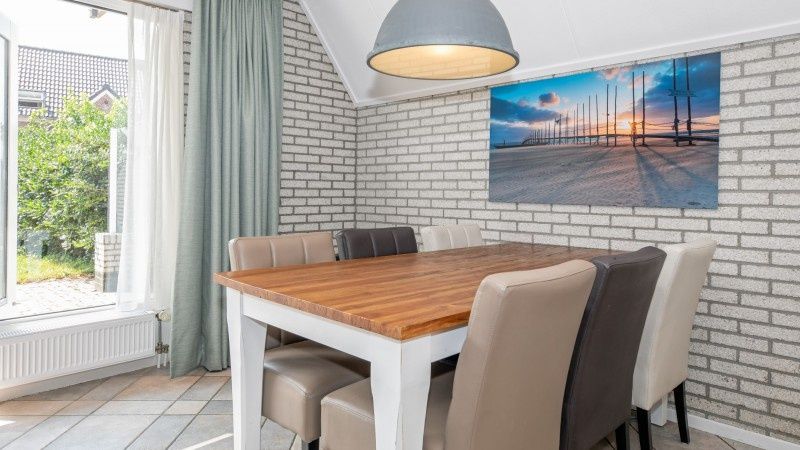 Dining area in Holiday home Schelpenoord 121, De Cocksdorp Texel, overlooking the garden.