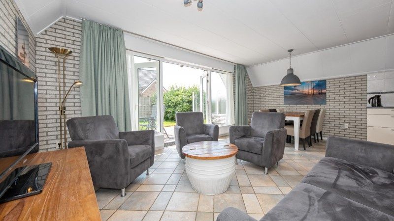 Spacious living room with garden view in Holiday home Schelpenoord 121, De Cocksdorp Texel.