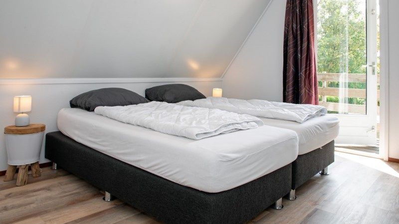 Bedroom with balcony in Holiday home Schelpenoord 121, De Cocksdorp Texel, offers views of nature.