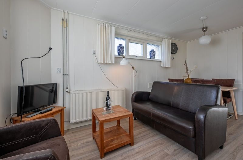 Gemuetliches Wohnzimmer des Ferienhauses Kikkertstraat 60, De Cocksdorp, Texel mit komfortabler Sitzecke.