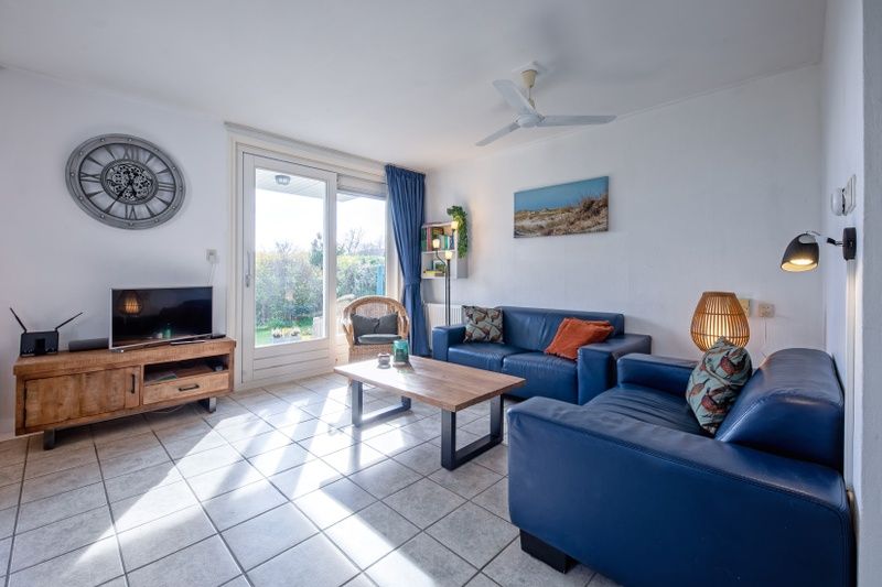 Lichte leefruimte in Vakantiehuis Slufterduin 52a, De Cocksdorp, Texel met uitzicht op de tuin.
