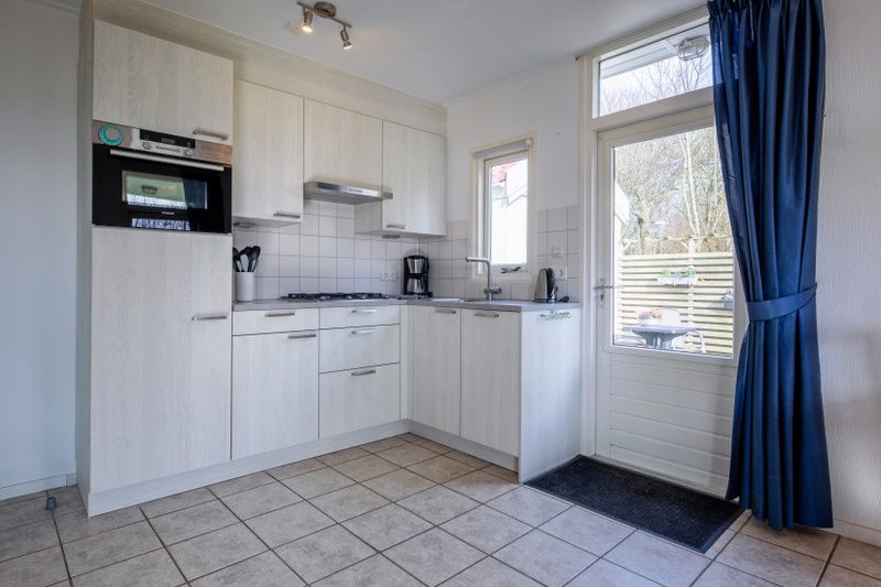 Stijlvolle keuken in Vakantiehuis Slufterduin 52a, De Cocksdorp, Texel met toegang tot terras.