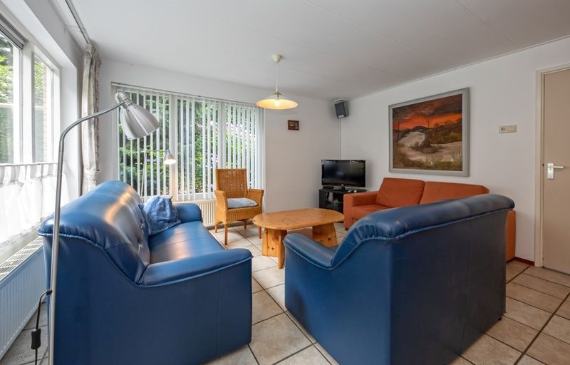 Gemuetliches Wohnzimmer des Ferienhauses Slufterduin 098 in De Cocksdorp, Texel, mit bequemen Sofas und viel Licht.