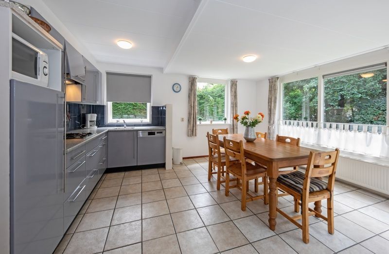 Geraeumige Kueche und Essbereich im Ferienhaus Slufterduin 098, Texel, mit modernen Geraeten und grossem Esstisch.