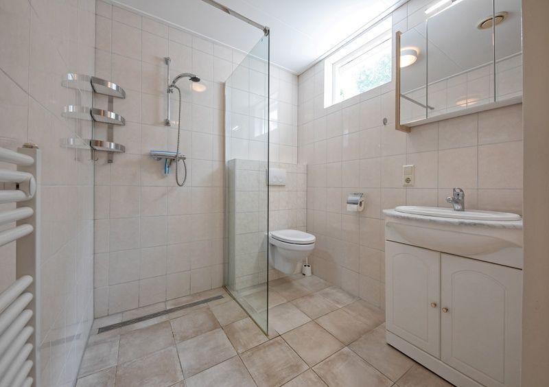 Modernes Badezimmer im Ferienhaus Slufterduin 098, De Cocksdorp, Texel, mit begehbarer Dusche und hellem Tageslicht.