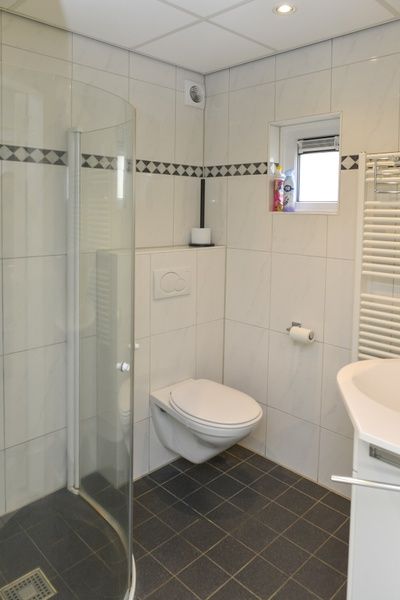 Modernes Badezimmer im Bungalow 9300, Texel, ausgestattet mit Dusche und Toilette, ideales Ferienhaus in De Cocksdorp.
