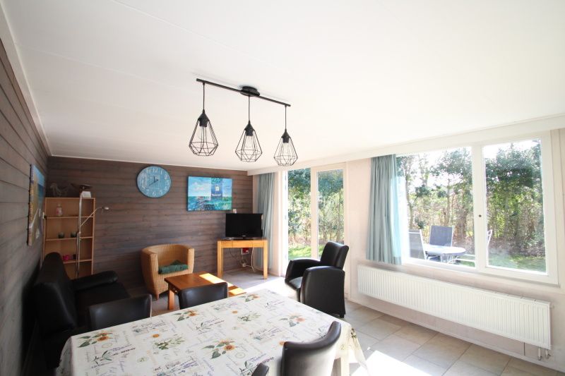 Helles Wohnzimmer im Bungalow Tamarisk 196, De Cocksdorp, mit Blick auf den Garten.
