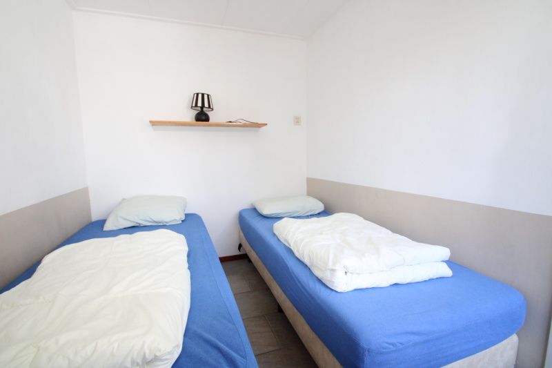 Schlafzimmer mit zwei Einzelbetten im Bungalow Tamarisk 196, De Cocksdorp.