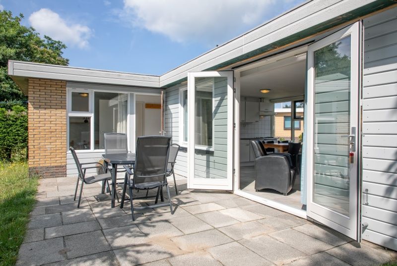 Sonnige Terrasse mit Terrassentueren im Bungalow Tamarisk 196, De Cocksdorp.