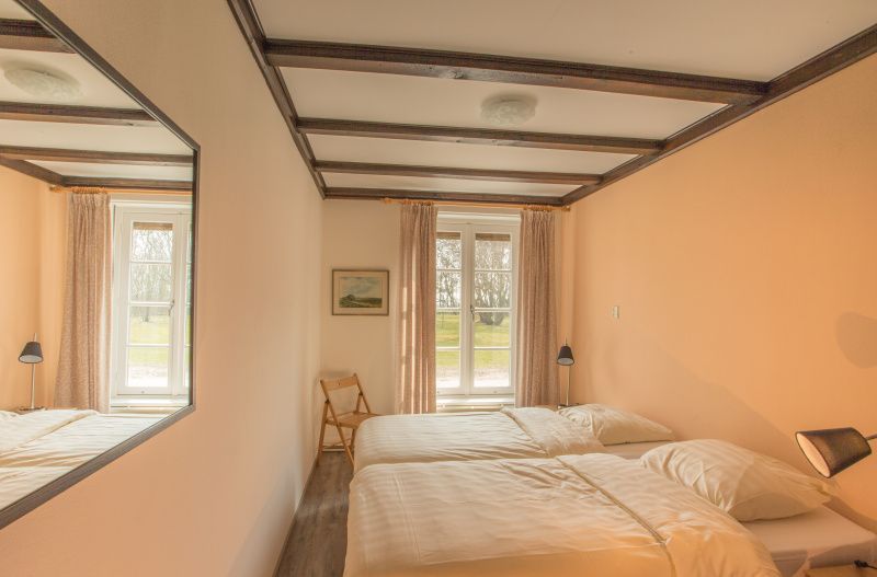 Schlafzimmer im Ferienhaus Typ R, De Cocksdorp, Texel, mit zwei Einzelbetten und viel Tageslicht.
