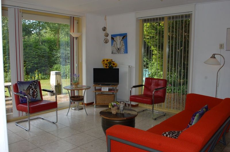 Gemuetliches Wohnzimmer im Bungalow Tamarisk 212, De Cocksdorp, Texel, mit Blick auf den Garten.