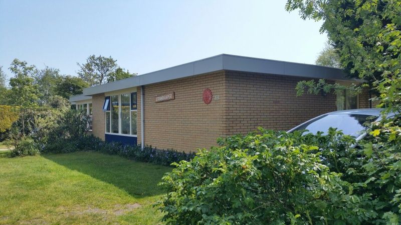 Aussenansicht des Bungalows Tamarisk 212 in De Cocksdorp, Texel, umgeben von gruener Natur.