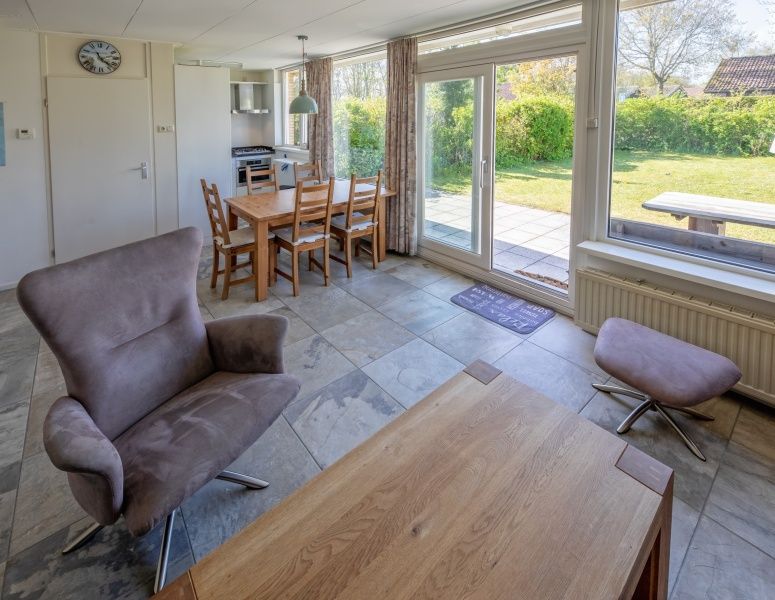 Ess- und Wohnbereich des Ferienhauses Slufterhoek 078, Texel, mit Blick in den Garten.