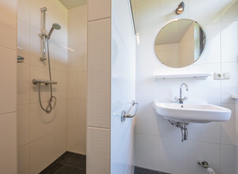 Stilvolles Badezimmer mit Dusche und Waschbecken im Ferienhaus Slufterhoek 078, De Cocksdorp.