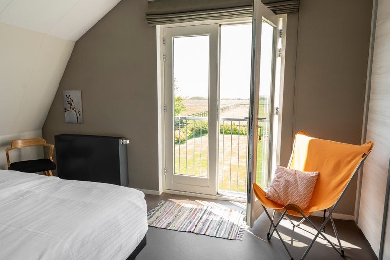Brightly decorated bedroom in Frederik and Lodevika vacation home, De Cocksdorp, Texel.