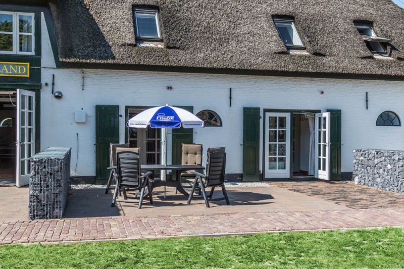 Zonnig terras bij Type S-2 vakantiehuis in De Cocksdorp, Texel met tuinmeubilair.