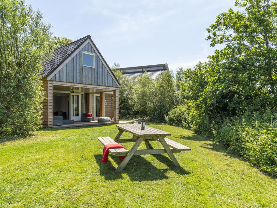 Geniessen Sie den gruenen Garten im Ferienhaus Zeewinde in De Cocksdorp, Texel. Perfekt fuer einen entspannten Aufenthalt auf den Watteninseln.