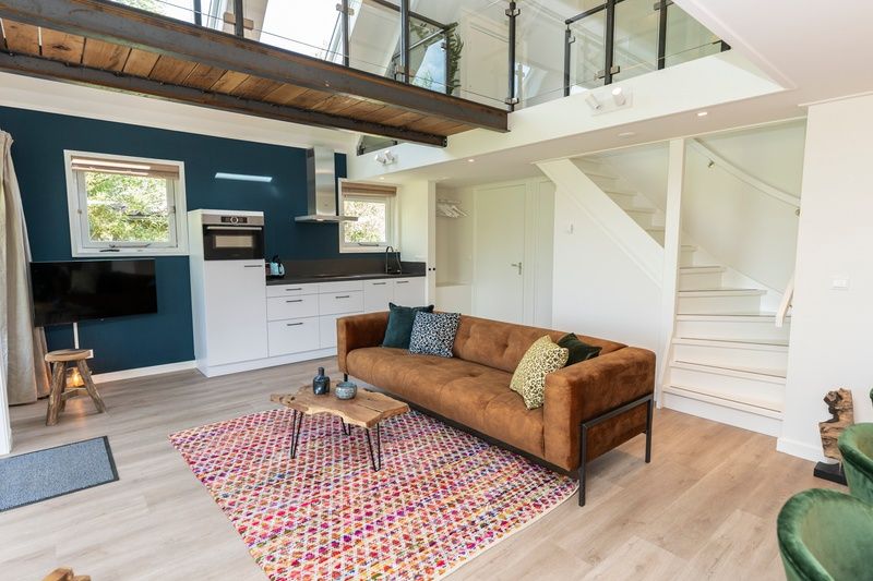 Geraeumiges Wohnzimmer mit Kueche im Ferienhaus Zeewinde, De Cocksdorp, Texel. Ideal fuer einen erholsamen Aufenthalt auf den Watteninseln.