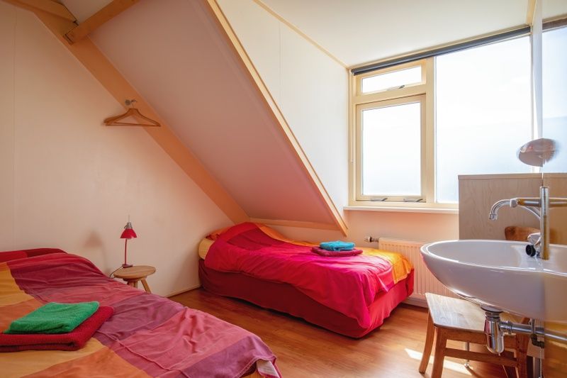 Gemuetliches Schlafzimmer mit zwei Betten im Ferienhaus Ganzenvlucht, De Cocksdorp, Texel, mit viel Tageslicht.
