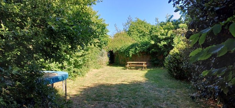 Weitlaeufiger Garten mit Picknicktisch im Ferienhaus Ganzenvlucht, De Cocksdorp, Texel, umgeben von ueppiger Natur.