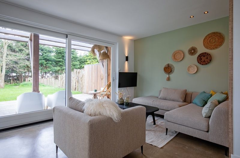Gemuetliches Wohnzimmer im Ferienhaus Brakzand, De Cocksdorp Texel, mit Blick auf den Garten.