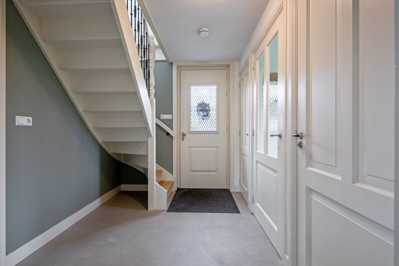 Eingang zum Bungalow Postweg 109 in De Cocksdorp, Texel, mit modernem Treppenhaus und hellem Flur in diesem stimmungsvollen Ferienhaus auf den Watteninseln.