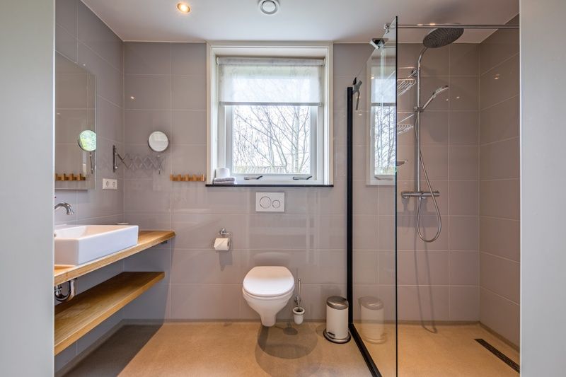 Modernes Badezimmer im Bungalow Postweg 109, De Cocksdorp, Texel. Luxus-Ferienhaus mit geraeumiger Dusche und eleganter Einrichtung auf den Watteninseln.