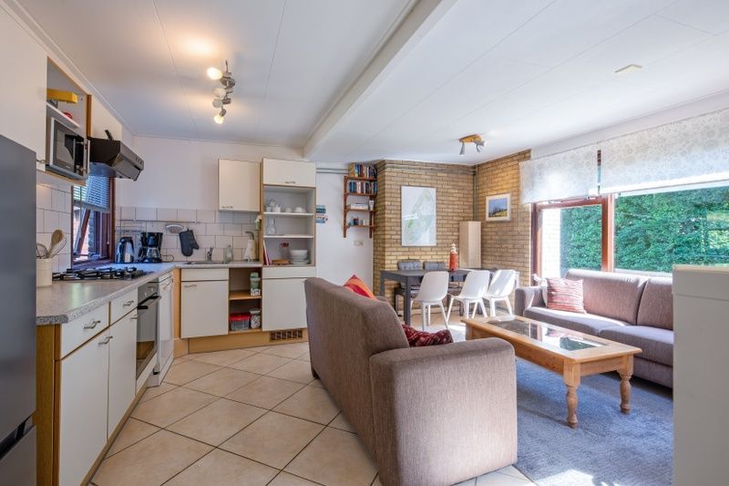 Geraeumiger Wohnbereich mit Kueche und Sitzecke im Ferienhaus Slufterduin 092 auf Texel.