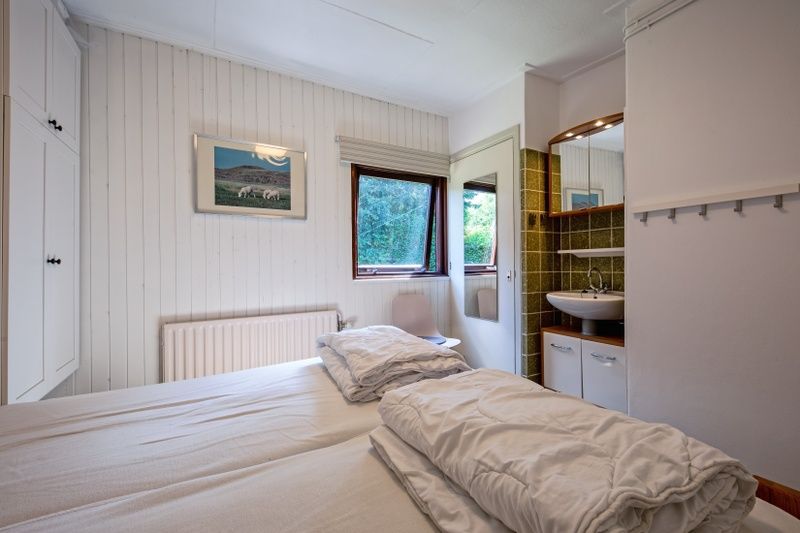 Schlafzimmer mit eigenem Waschbecken im Ferienhaus Slufterduin 092, De Cocksdorp, Texel.
