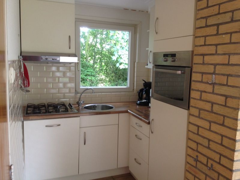 Vollstaendig ausgestattete Kueche im Ferienhaus Slufteroord 270, De Cocksdorp Texel, mit modernen Geraeten und Blick auf die Natur.