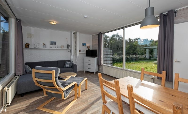 Cozy sitting area in Bungalow Tamarisk 190, De Cocksdorp, Texel, overlooking the garden.