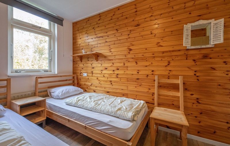 Cozy bedroom in Bungalow Tamarisk 190, De Cocksdorp, Texel, with wooden interior.
