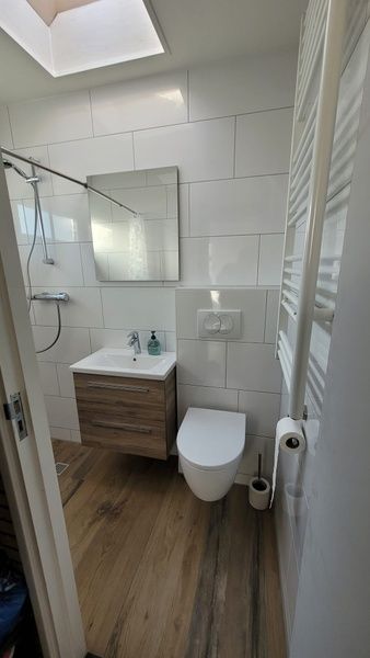 Modern bathroom of Bungalow Tamarisk 190, vacation home on Texel, with shower and sink.