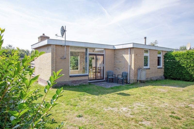 Backyard of Bungalow Tamarisk 190 on Texel, with green surroundings and terrace.