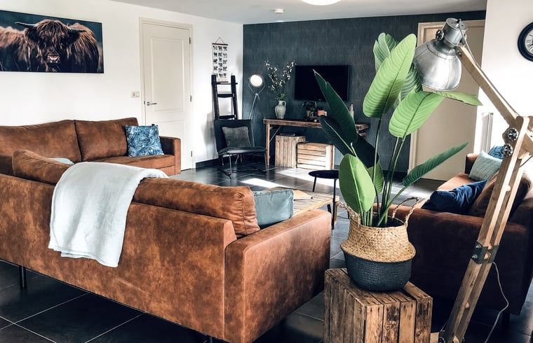 Stilvolles Wohnzimmer im Ferienhaus in De Cocksdorp, Texel, mit bequemen Ledersofas.