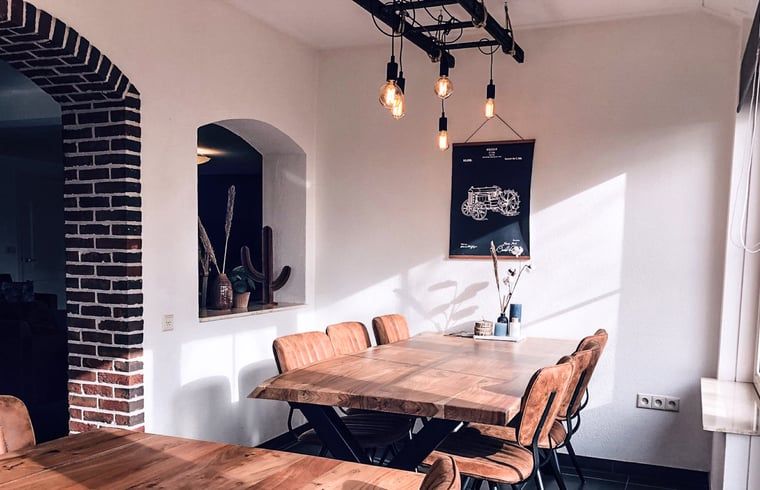 Essecke im Ferienhaus in De Cocksdorp, Texel, mit gemauertem Bogen und Holztisch.