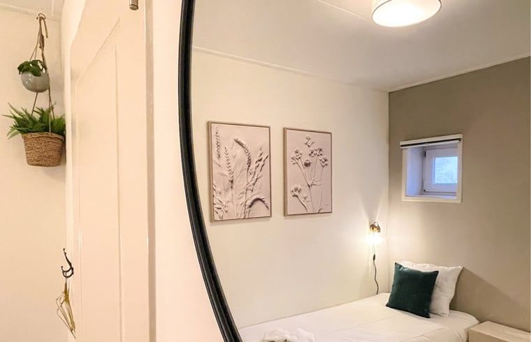 Schlafzimmer im Ferienhaus in De Cocksdorp, Texel, mit Kunst an der Wand und Einzelbett.