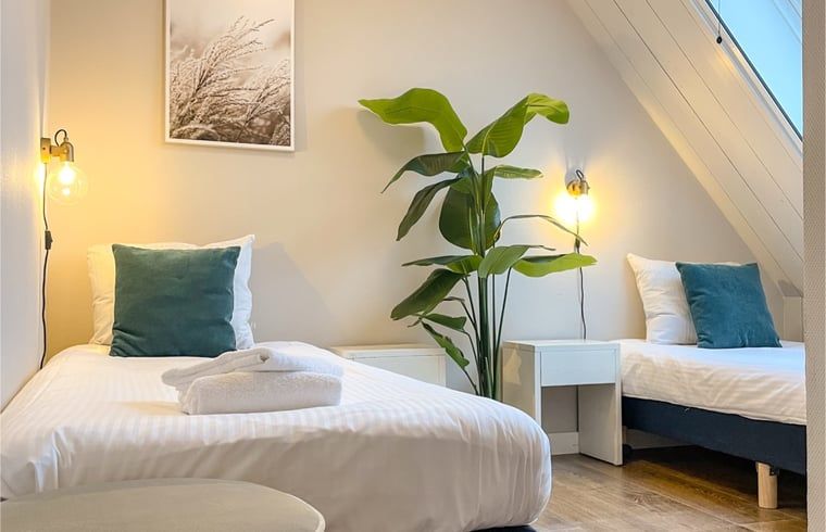 Schlafzimmer mit zwei Einzelbetten im Ferienhaus in De Cocksdorp, Texel.